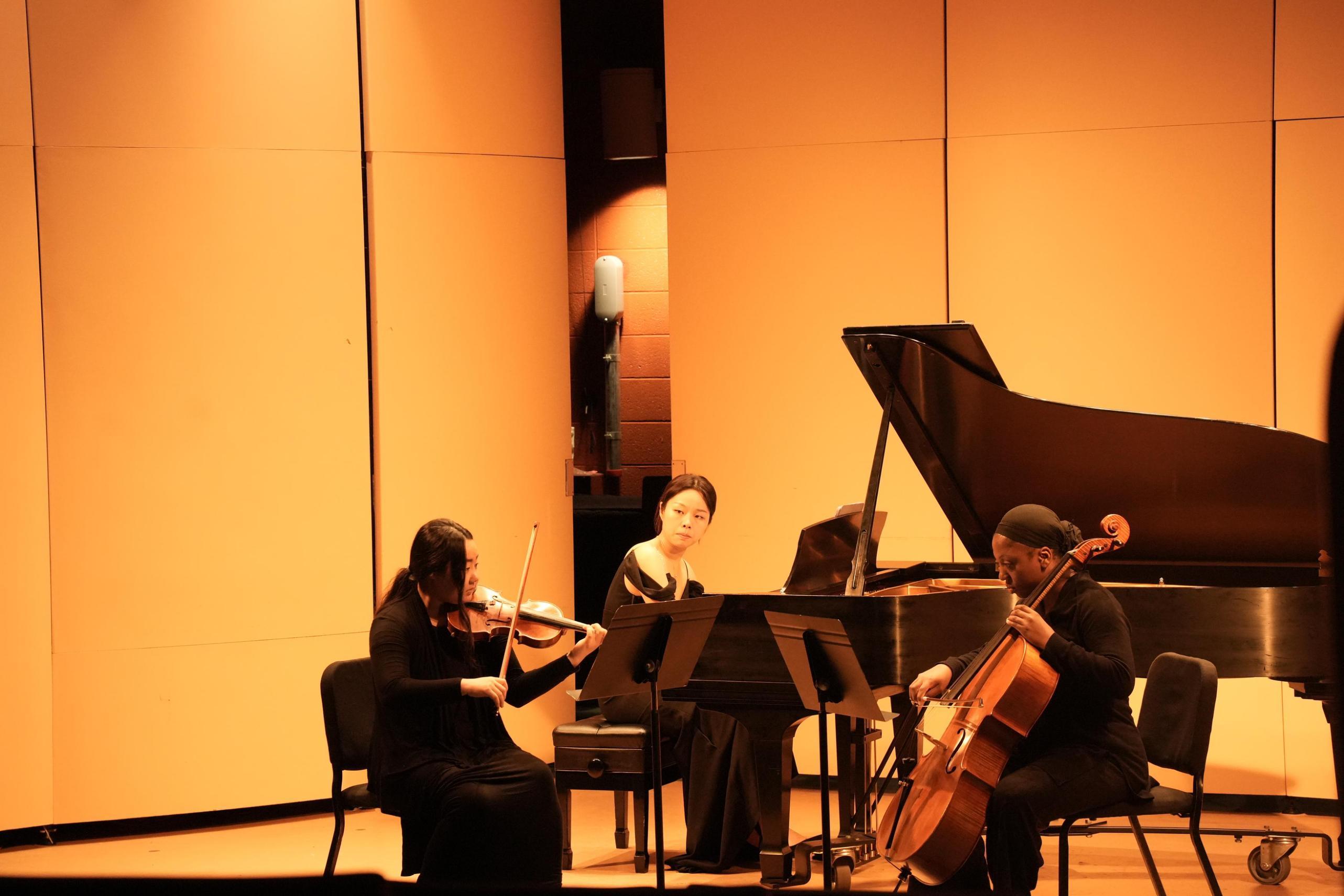 Yueheng Lin performing chamber music with violin and cello