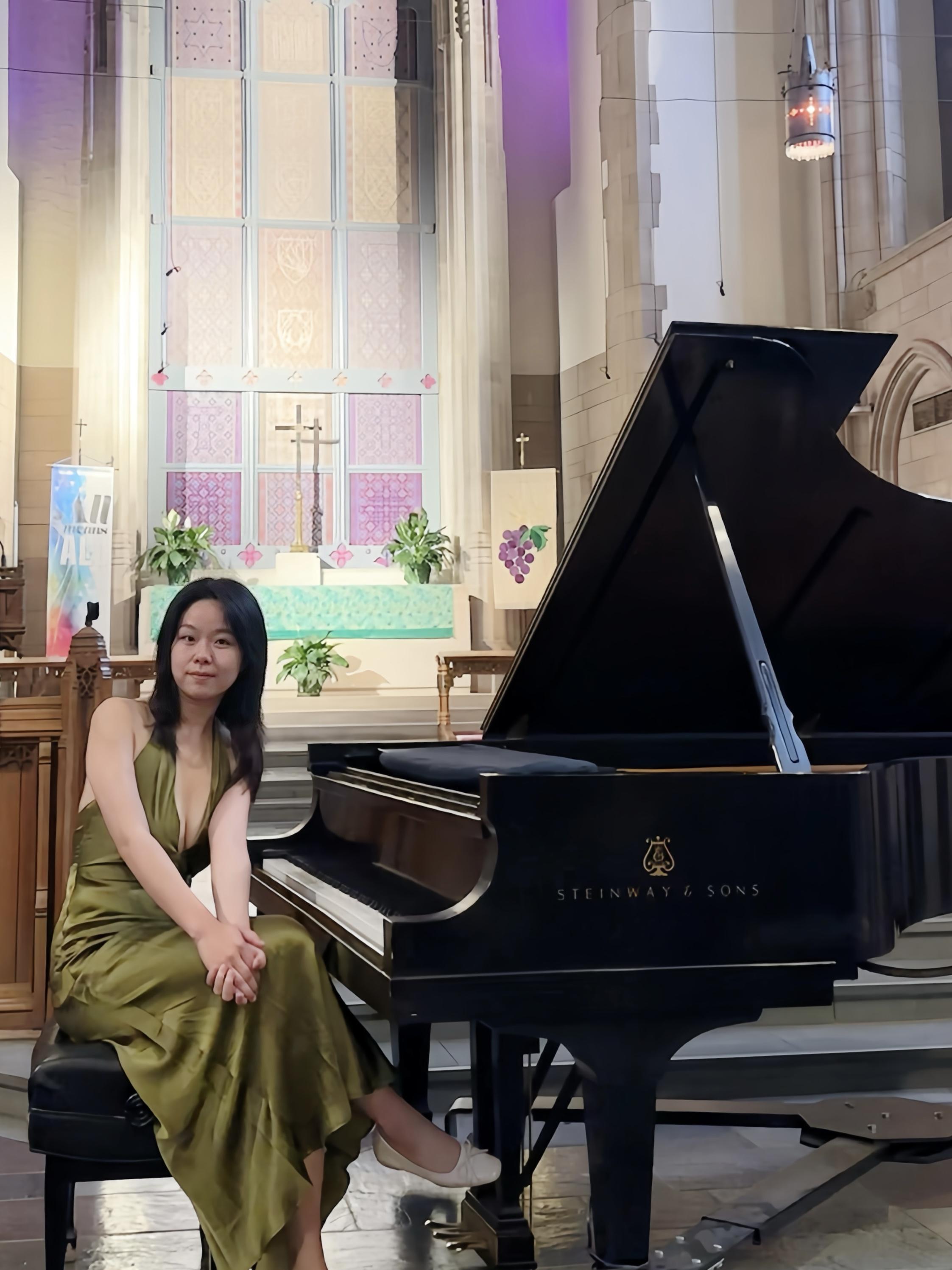 Yueheng Lin seated beside a Steinway grand piano